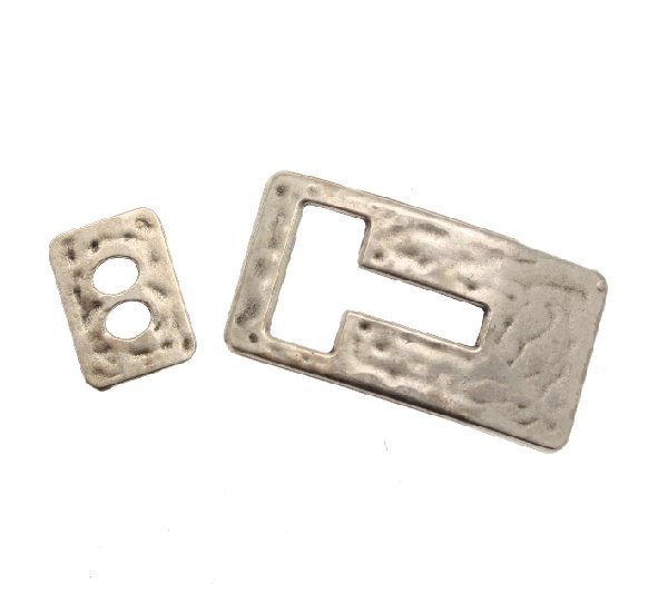 Chiusura per cordoncino in pelle piatto, a forma di rettangolo martellato con foro a "T", 37x18 mm.