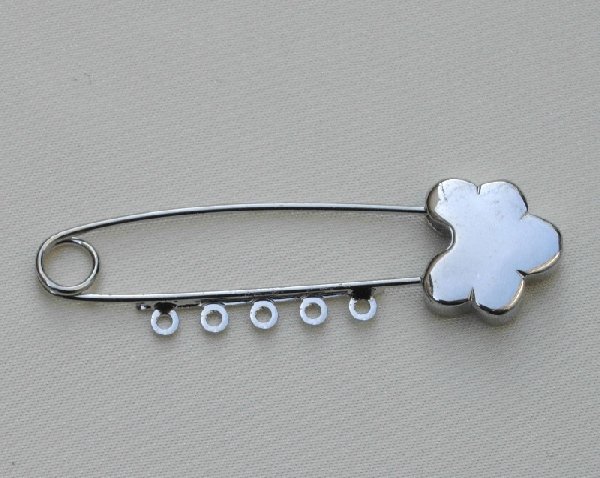 Spilla da balia con lavorazione in punta a fiore e 5 anelli 55 mm.